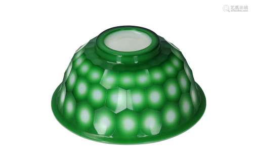 A green on white glass bowl with a hexagonal carved decorati...
