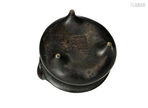 A tripod bronze censer with two handles, on a bronze base. M...