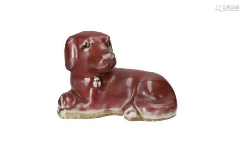 A sang de boeuf glazed porcelain sculpture of a dog with bla...