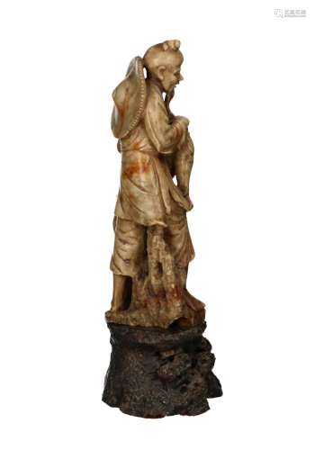 A soapstone sculpture of a fisherman on a rock. Unsigned. Ch...