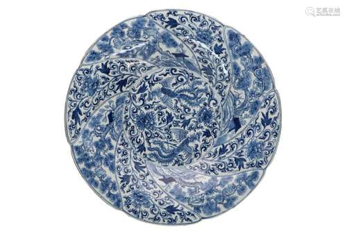 A blue and white porcelain charger with scalloped rim, decor...