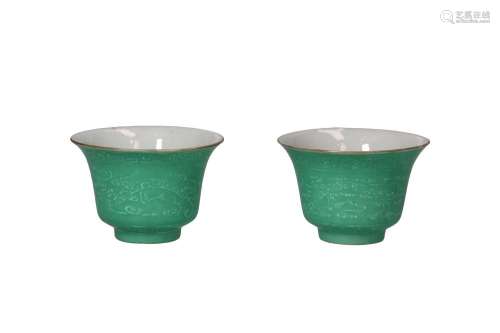 A pair of green glazed porcelain cups, decorated in relief w...