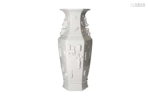 A hexagonal blanc de Chine vase with grips in the shape of s...