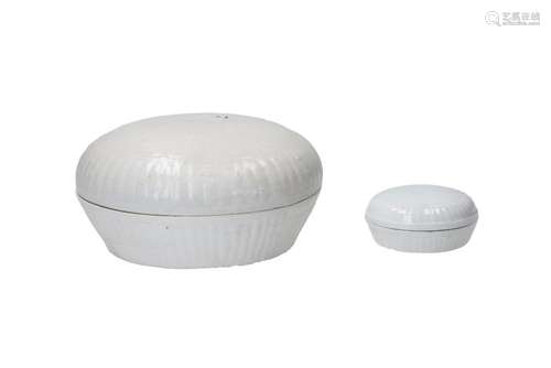 Two round porcelain lidded boxes with relief decor. The larg...