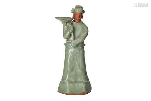 A celadon glazed terracotta sculpture of a servant, carrying...