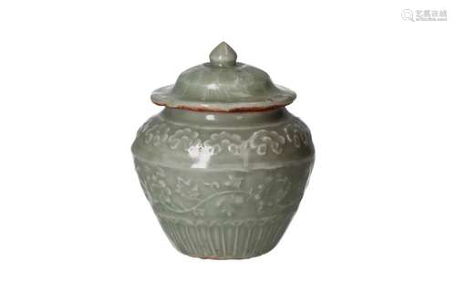 A celadon glazed lidded vase, decorated in relief with flowe...