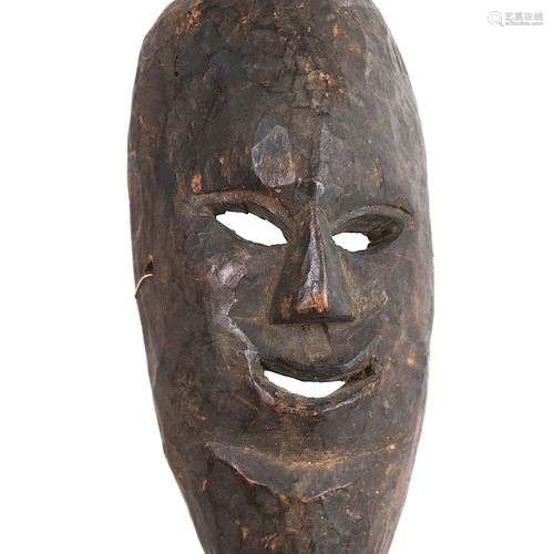 Congo. Masque en bois foncé de forme ovale, le visage allong...