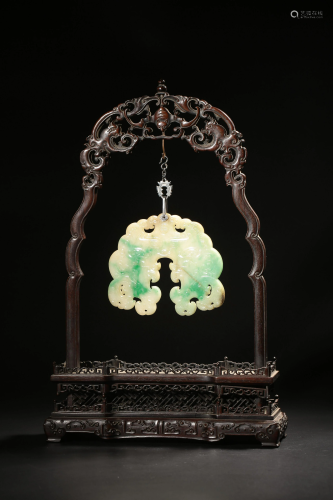 A Chinese emerald jade carved pendant, fastened on a