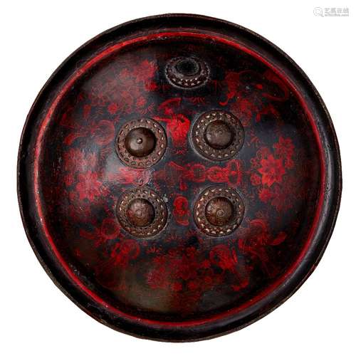 A lacquered rhino hide shield with figurative decoration, Ra...