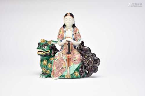 A Japanese Kutani figure of Kannon seated on a lion