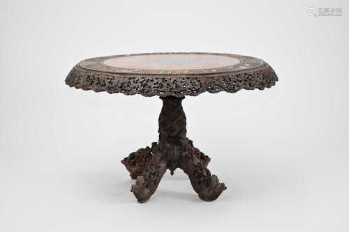 A large Burmese carved hardwood tilt-top table