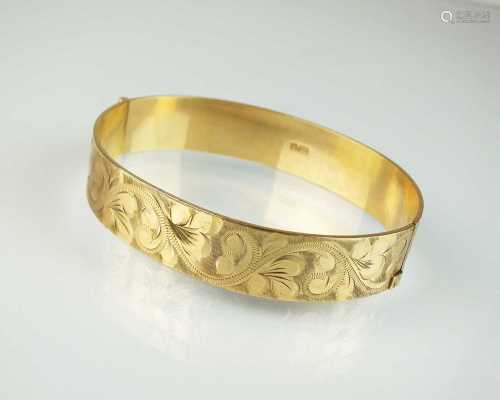 A 9ct gold bright cut engraved hinged bangle