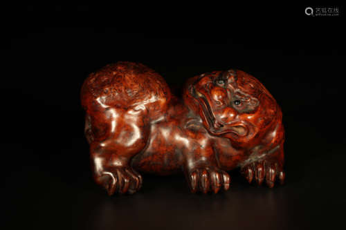 A Carved Burlwood Lion-Form Ornament