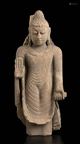 A STONE SCULPTURE OF A STANDING BUDDHA India, 20th