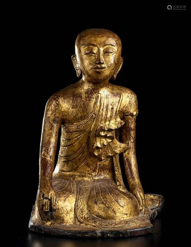 A LACQUERED AND GILT WOOD SCULPTURE OF A MONK Th…