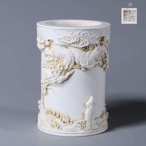 A carved cloud and dragon porcelain brush pot