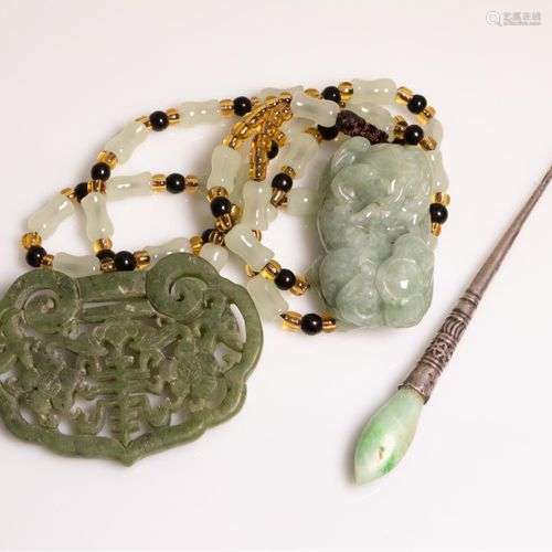 Un collier en partie en jade avec un pendentif en forme de c...