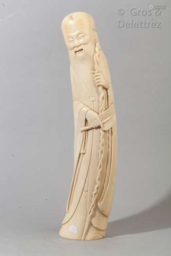 Sujet en ivoire représentant une divinité tenant un bâton et...