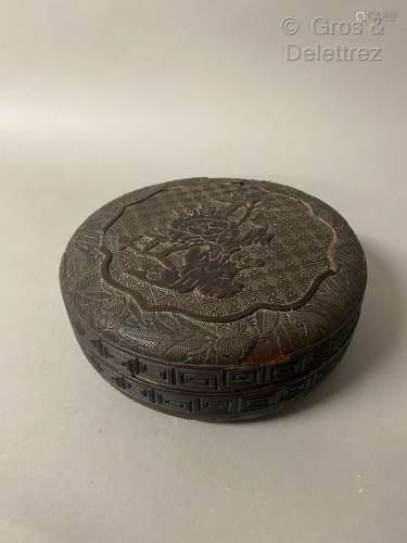 Chine. Boîte circulaire en bois laqué brun à décor sculpté d...