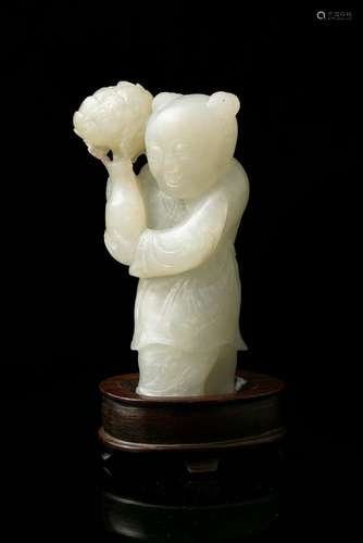 A WHITE JADE FIGURE OF A STANDING BOY WITH A LOTUS FLOWER VA...