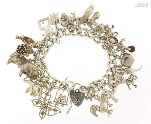 Silver charm bracelet with a selection of mostly silver