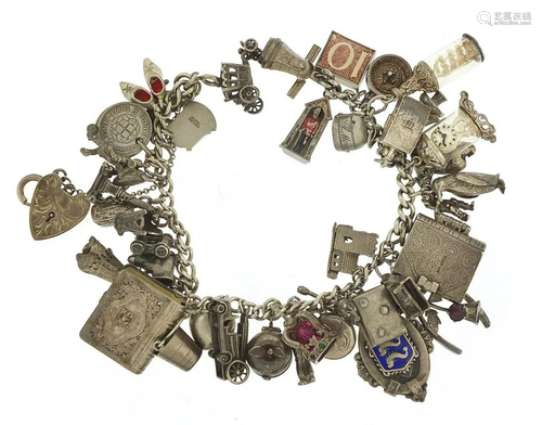 Heavy silver charm bracelet with a large selection of