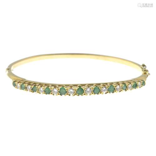 An emerald and diamond bangle, hinged to the plain reverse.