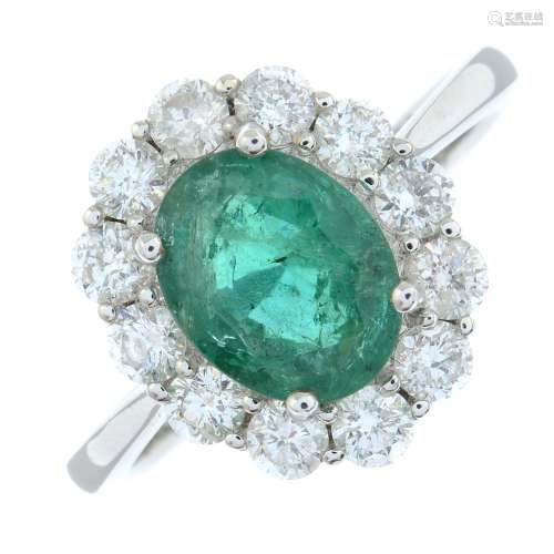 An 18ct gold emerald and brilliant-cut diamond cluster ring....