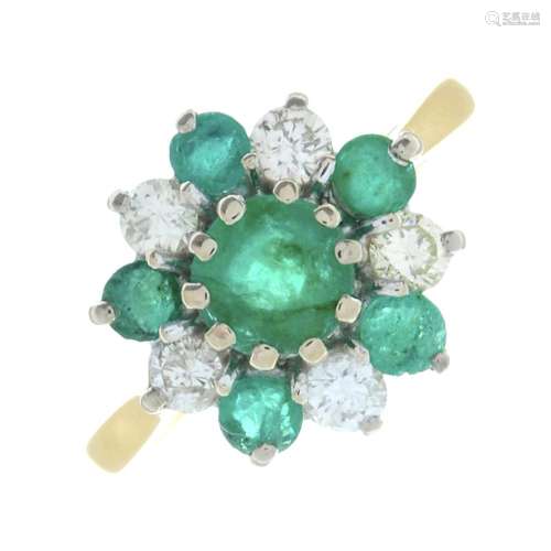 An 18ct gold emerald and brilliant-cut diamond cluster ring....