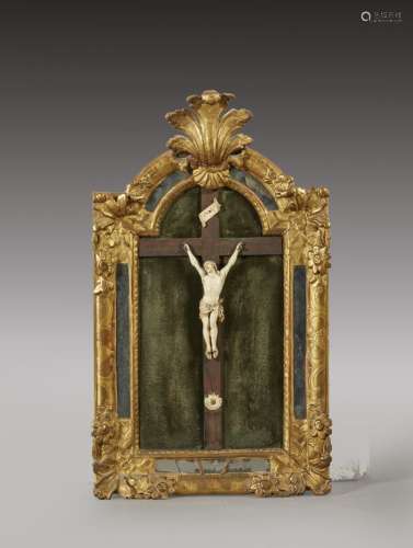 Crucifix en ivoire, dans un cadre cintré en bois doré à déco...
