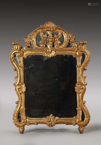 Miroir en bois doré à décor ajouré de rinceaux de feuillages...