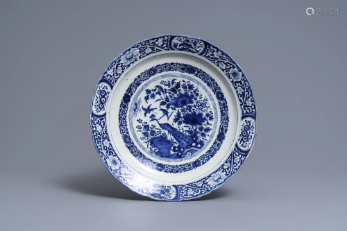 A Dutch Delft blue and white dish with a peacock in a