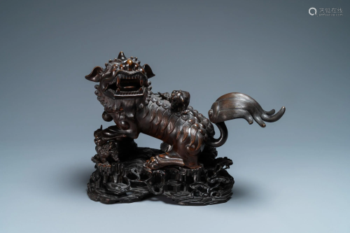 A Chinese bronze model of a Buddhist lion on a finely