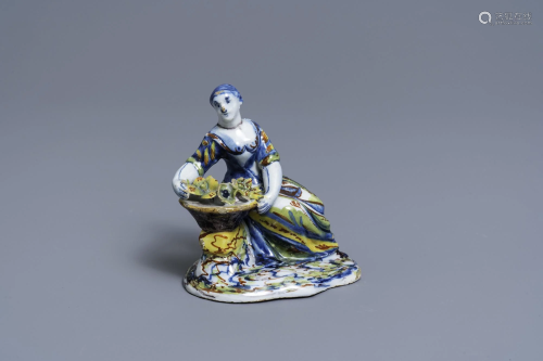 A polychrome Dutch Delft figure of a lady selling