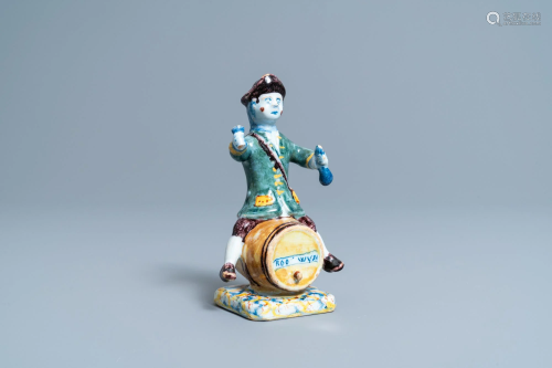 A polychrome Dutch Delft figure of a wine drinker on a