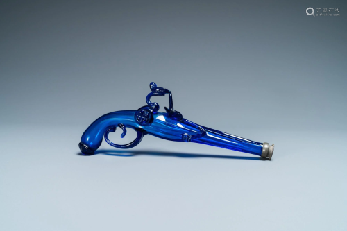 A cobalt blue glass flask in the shape of a flintlock
