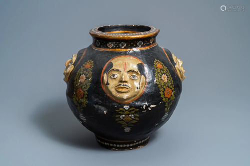 A relief-decorated papier-m‰che vase with four faces,