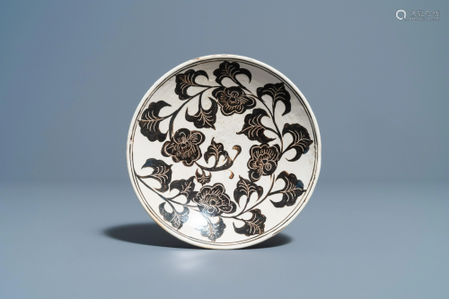 A Chinese Cizhou plate with carved floral design,