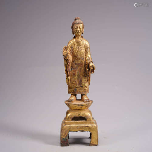 An archaistic gilt bronze statue of buddha