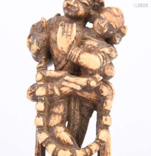 Statuette votive en os, représentant un couple enlacé tenant...