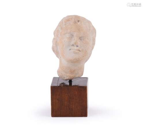 A CARVED MARBLE HEAD OF A CHILD, IN THE 1ST/2ND CENTURY AD R...