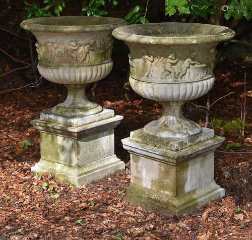 A LARGE PAIR OF COMPOSITION STONE URNS WITH CHERUB RELIEFS, ...