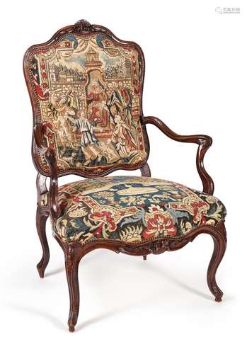 A LOUIS XV CARVED WALNUT AND NEEDLEWORK UPHOLSTERED ARMCHAIR...