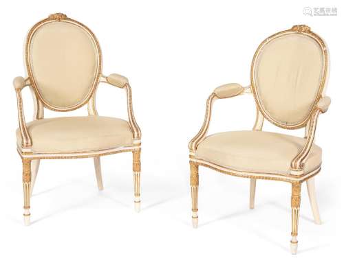 A PAIR OF GEORGE III CREAM PAINTED AND PARCEL GILT OPEN ARMC...