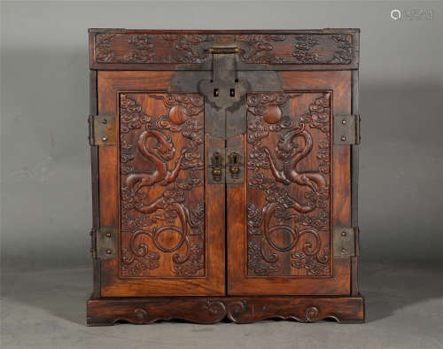 A CHINESE HUANGHUALI CABINET CARVED WITH DRAGONS