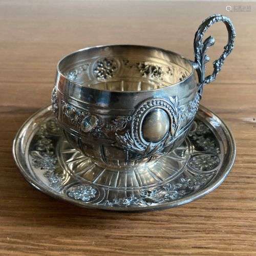 Tasse et sa sous-tasse en argent 950, décor en repoussé de g...