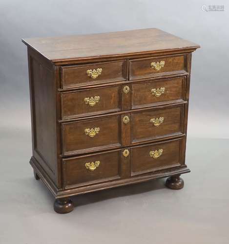 A late 17th century oak chest,of four graduated long drawers...