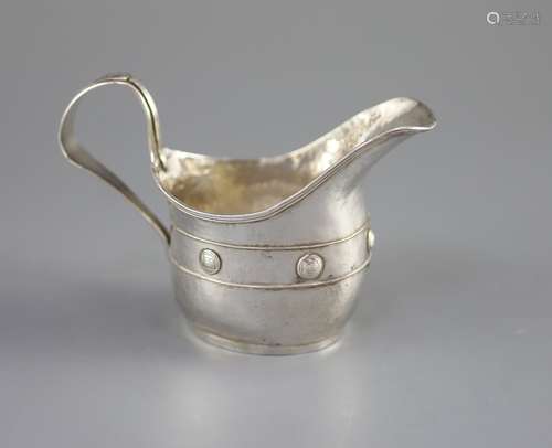 An Edwardian Arts & Crafts planished silver cream jug by Joh...