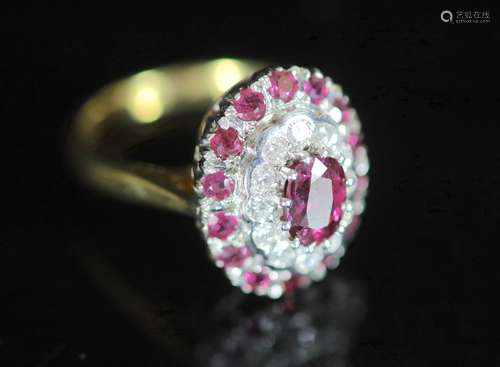 A modern 18ct gold, ruby and diamond set oval cluster ring,w...