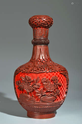 A CARVED CINNABAR AND BROWN LACQUER FLORAL GARLIC-HEAD-SHAPE...